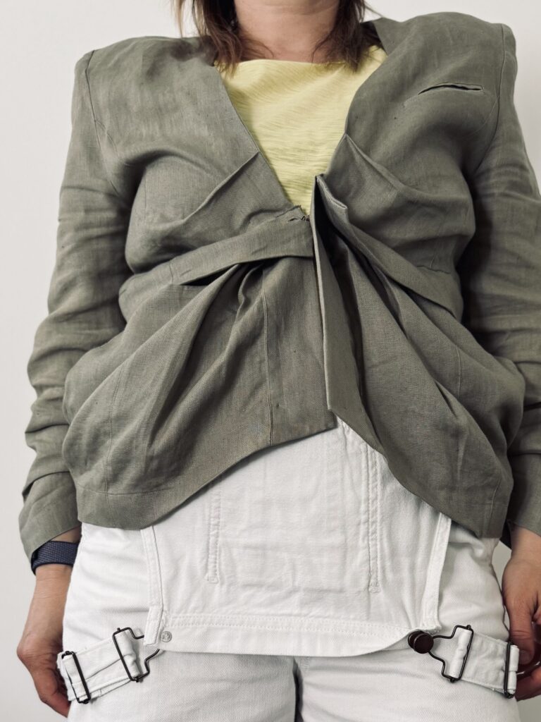 Olive green blazer with hidden pockets and tulip downer part. Front. Closed.