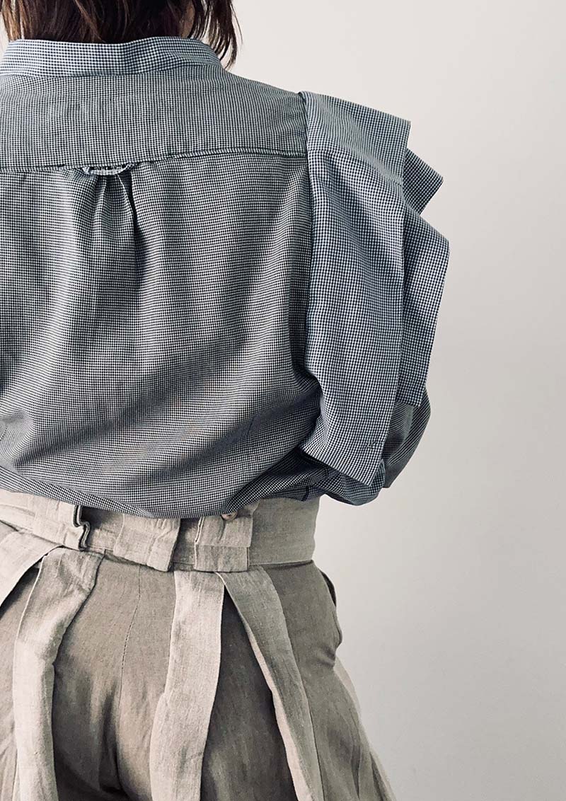 Blouse with big pleats Nr1.2 worn with linen trousers, zoomed back view. Upcycling logic.